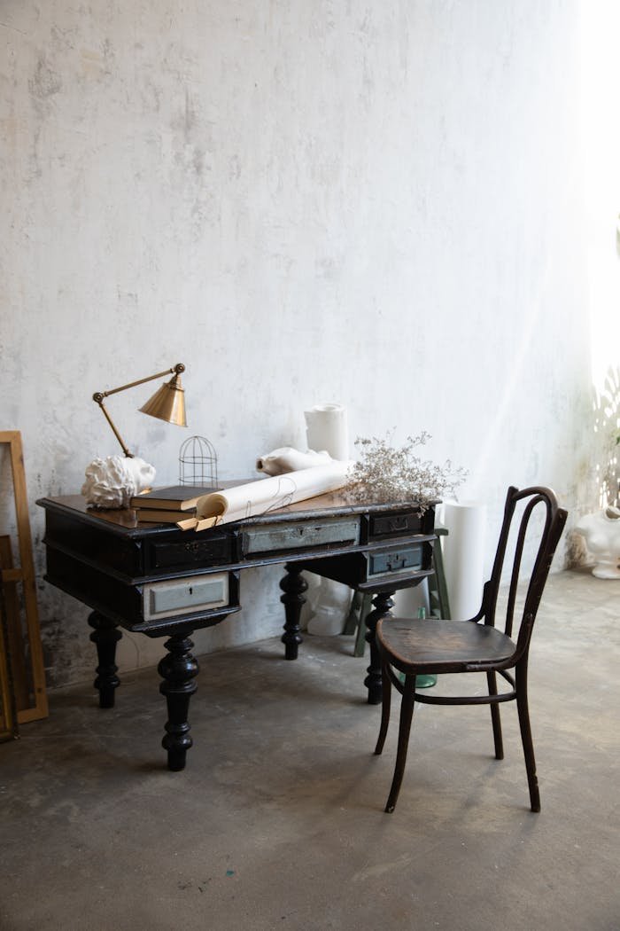 Cozy vintage study room with antique desk and chair in a minimalist setting.